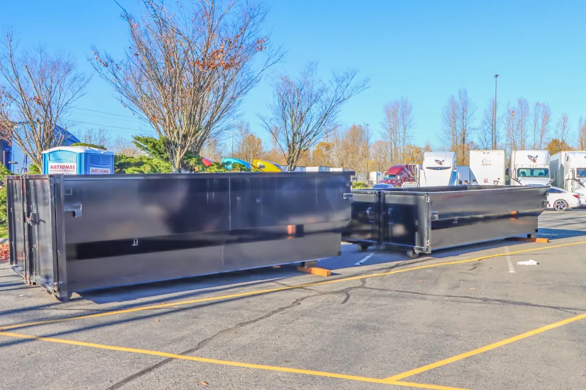 Professional dumpster rental service with roll-off container on residential driveway in Fort Rucker